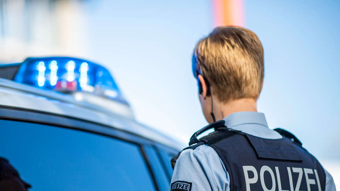 Ein Polizist aus Nordrhein-Westfalen steht vor einem Einsatzfahrzeug